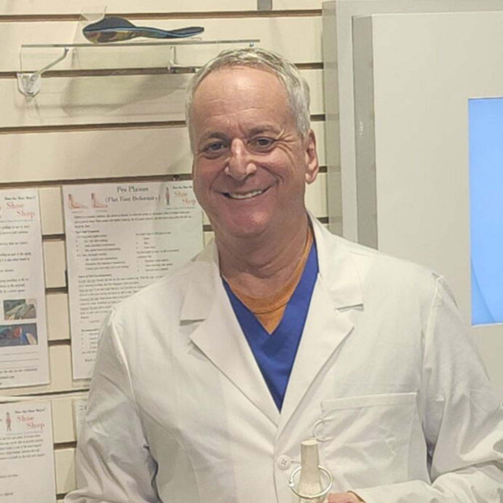 Rob the pedorthist in a white lab coat standing in a medical office setting