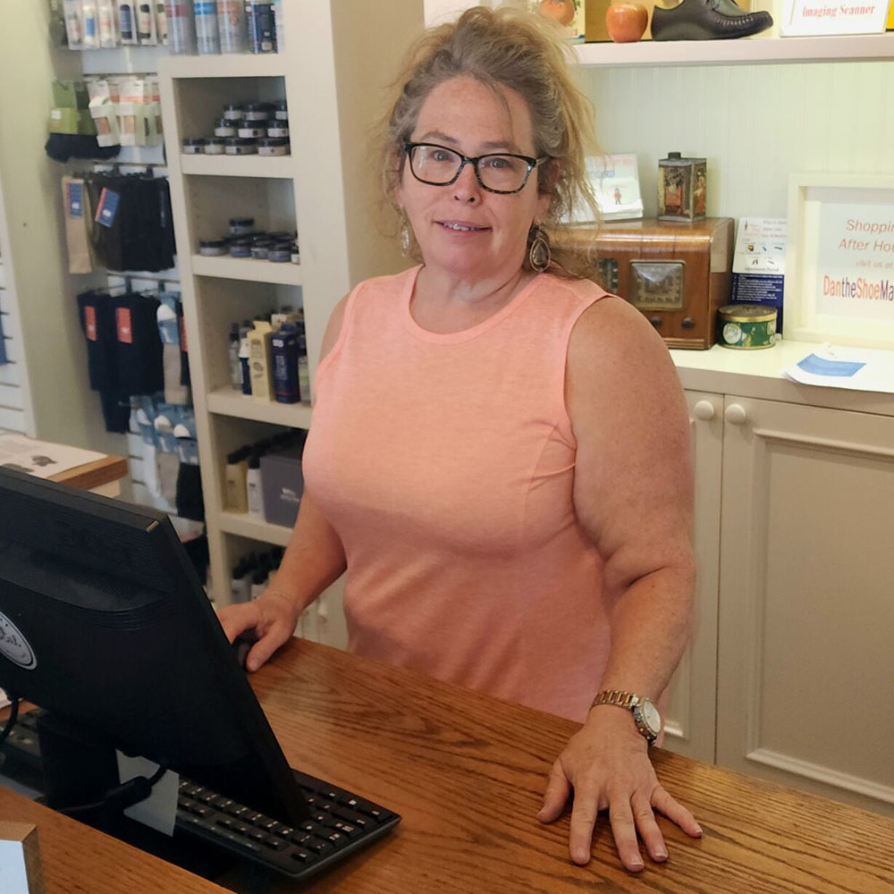 Susan standing behind the till counter 
